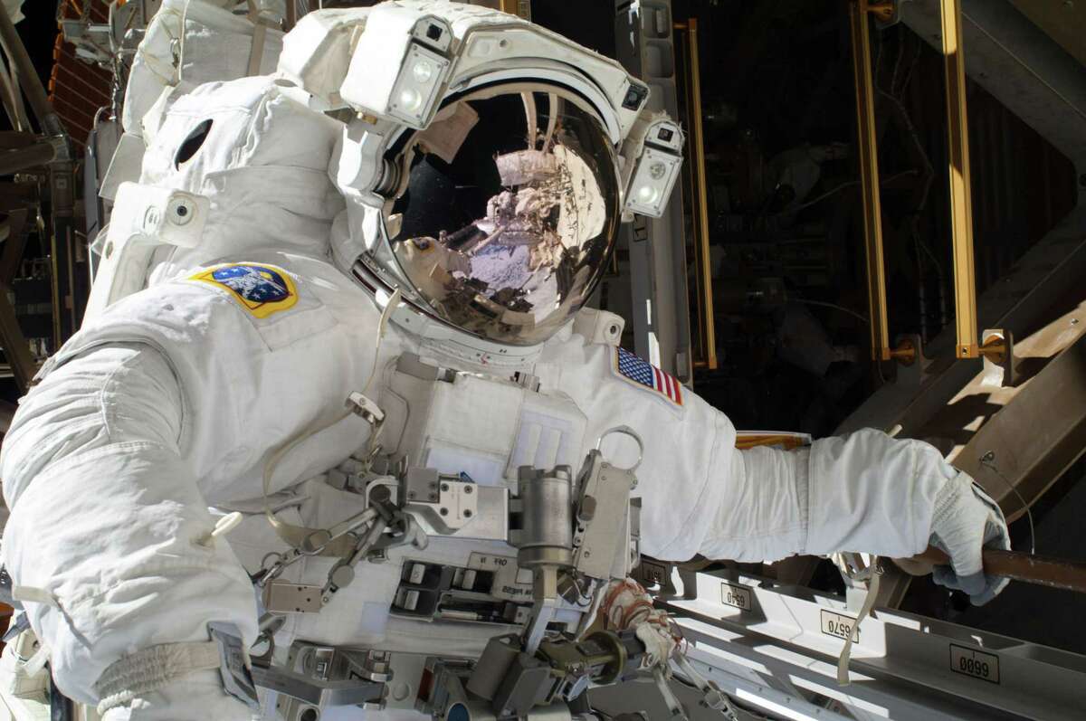 In this Saturday, Dec. 21, 2013 photo provided by NASA and tweeted Sunday, Dec. 22, by NASA astronaut Michael Hopkins, Hopkins work to repair an external cooling line on the International Space Station on a spacewalk 260 miles above Earth. (AP Photo/NASA)