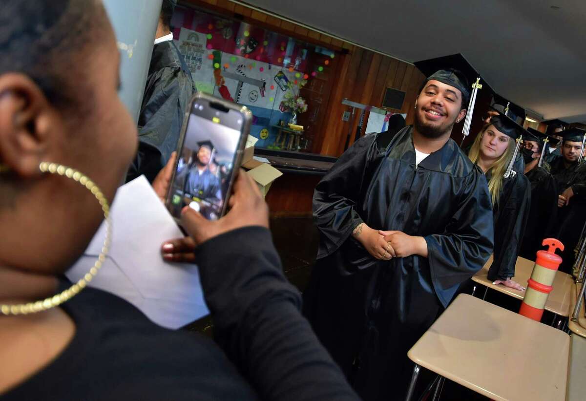 Angel Ford takes a picture of her son Josiah Gonzalez before the start of Stamford Public Schools Adult and Continuing Education Class of 2022 Graduation at Rippowam Middle School in Stamford, Conn., on Wednesday June 1, 2022