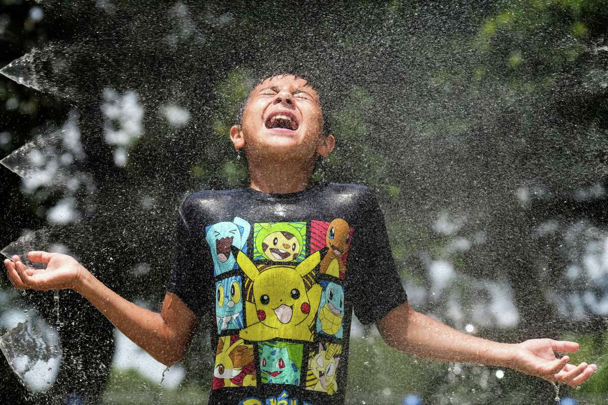 Mark Moreno takes advantage of the splash pad at Melrose Park to cool off Tuesday, May 31, 2022 in Houston. Temperatures in Houston could hit triple-digits this week, which could push Texans to use a record-breaking amount of electricity.