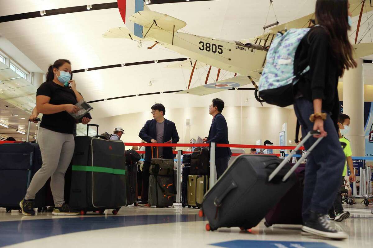 Travelers check in and head to gates at San Antonio International Airport on May 27.