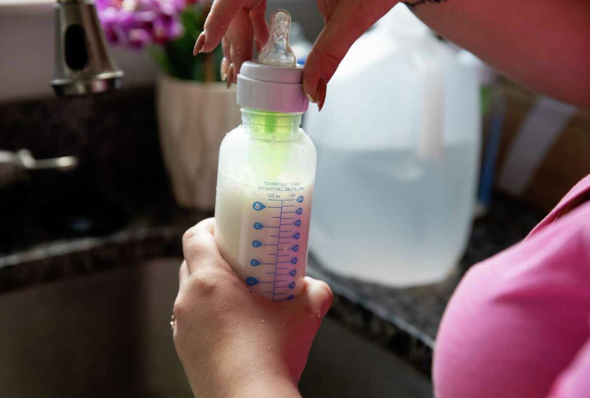 A mother prepares a bottle of baby formula in Plymouth, Mass., amid the ongoing shortage that has left parents desperately searching for ways to feed their infants. 