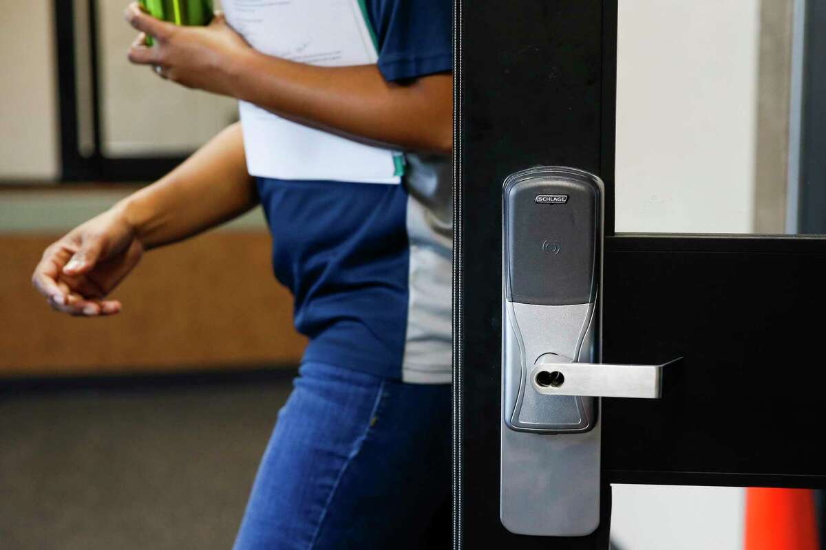 A principal walks next to an automatic lock outside a new security vestibule that has been added at Albright Middle School, shown Tuesday Aug. 14, 2018 in Houston. The vestibule lets staff to interact with visitors before allowing them access to the building and also has a 911 call button.
