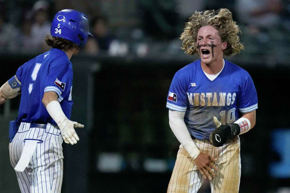 Friendswood’s Ayden Pearcy, right, reacts after scoring a run during the sixth inning of Game 2 of the Region III-5A Championship high school baseball playoff series against Lake Creek, Thursday, June 2, 2022, in Houston.