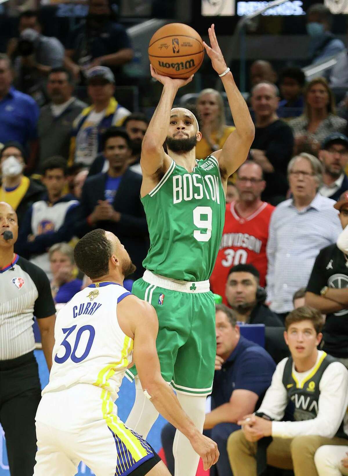 Boston Celtics’ Derrick White shoots a 3-pointer against Golden State Warriors’ Stephen Curry in 4th quarter during Celtics’ 120-108 win in Game 1 of NBA Finals at Chase Center in San Francisco, Calif., on Thursday, June 2, 2022.