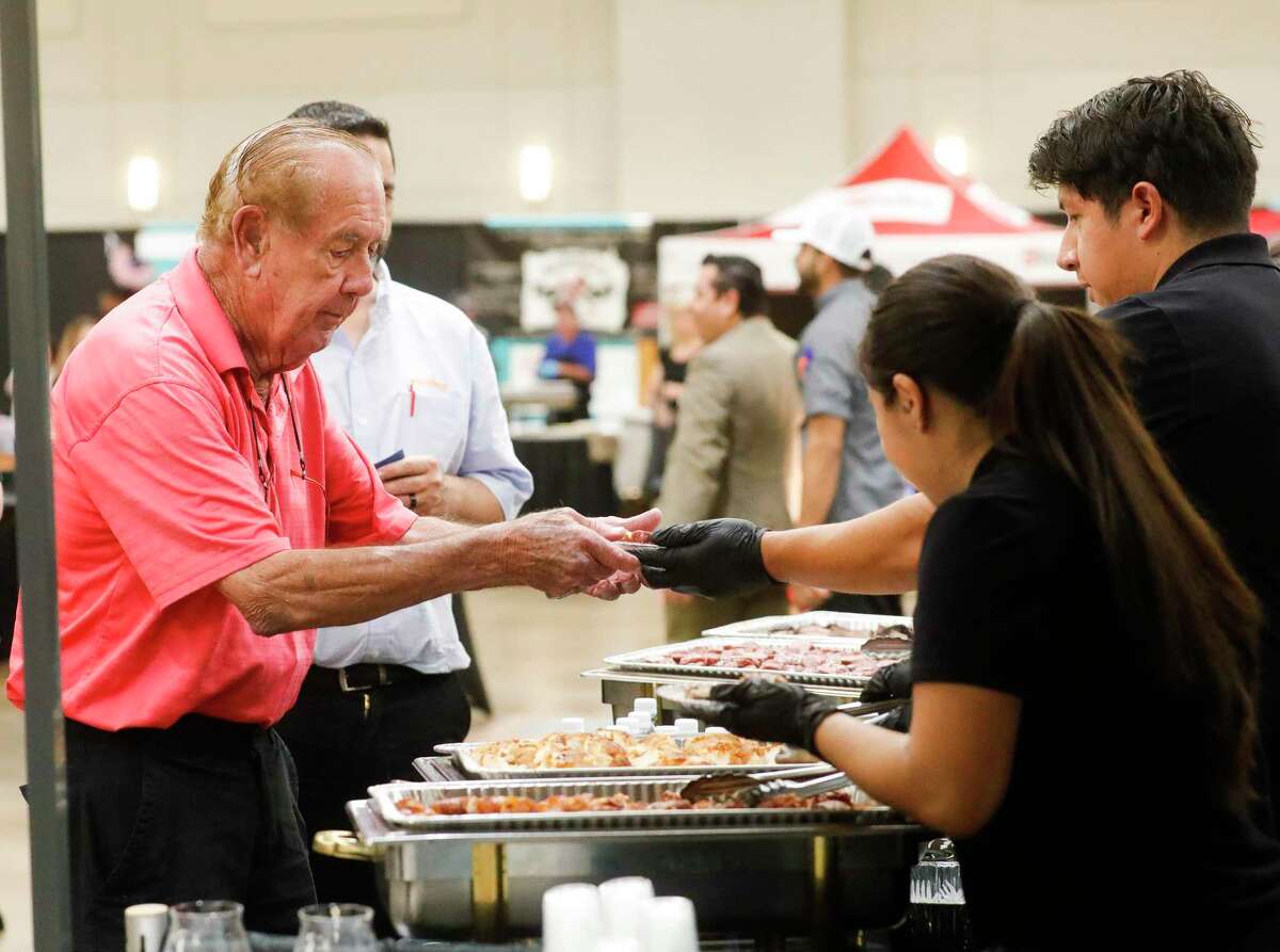 Ray Mason gets samples of food from Mckenzie's Barbeque during the Conroe Chamber of Commerce’s annual Tastefest at the Lone Star Convention & Expo Center, Thursday, June 2, 2022, in Conroe. Five hundred guest enjoyed food at the hybrid event, where guest used their pass to enjoy the in-person event, as well as the ability to use it to dine at participating restaurants through the month of June.