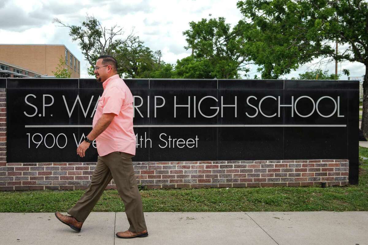 Jesse Espinosa, the outgoing band director at HISD's Waltrip High, walks outside the school on Wednesday, June 1, 2022 in Houston. Espinosa, who graduated from Waltrip, has led the band to praise and recognition during his tenure but is leaving the district because of what he feels is a lack of support for the fine arts.