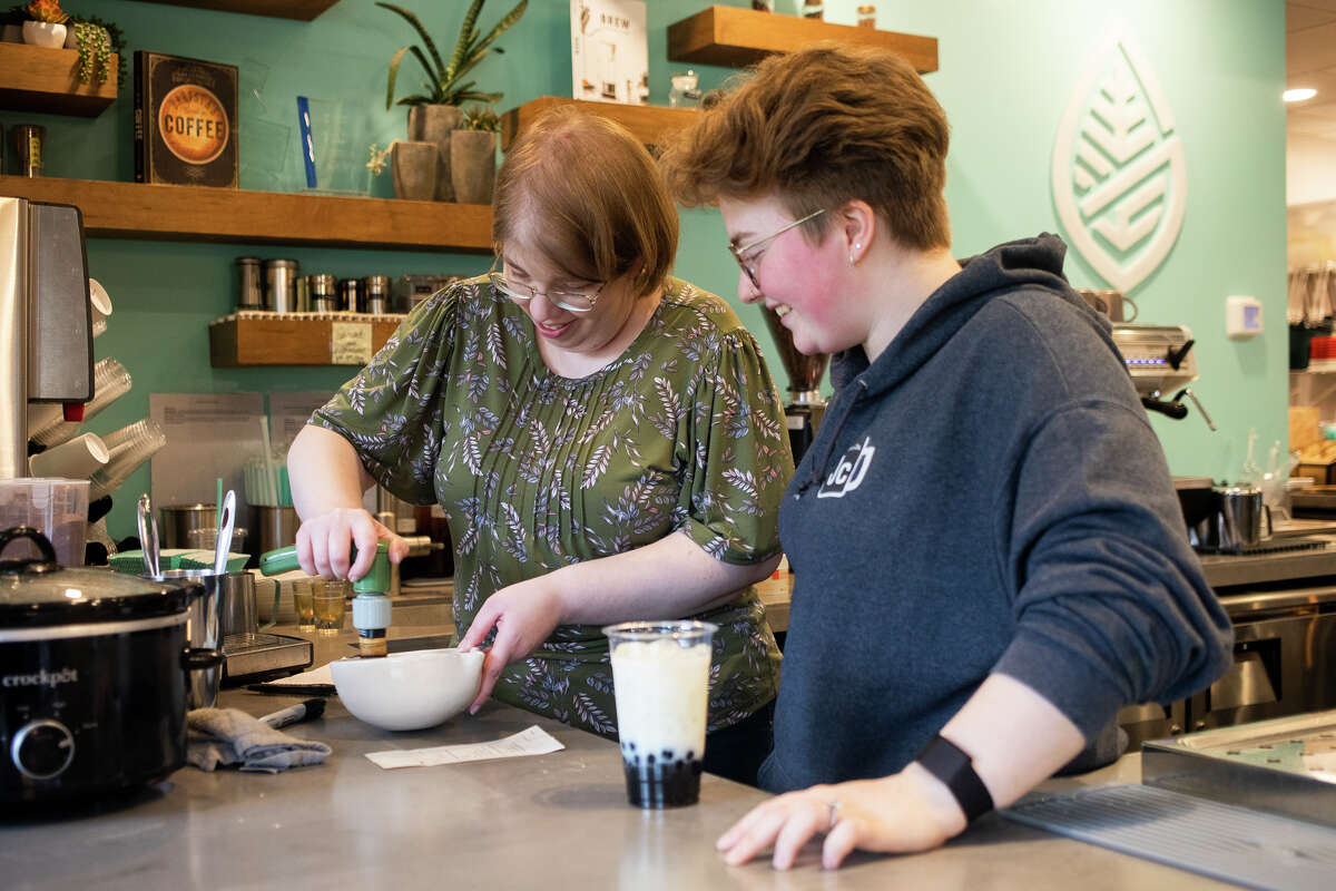 Grace LaBonte, right, a barista at Grove Tea Lounge, gives pointers on whisking matcha powder to Midland Daily News reporter Victoria Ritter, left, Tuesday, May 3, 2022 at the cafe in Midland.