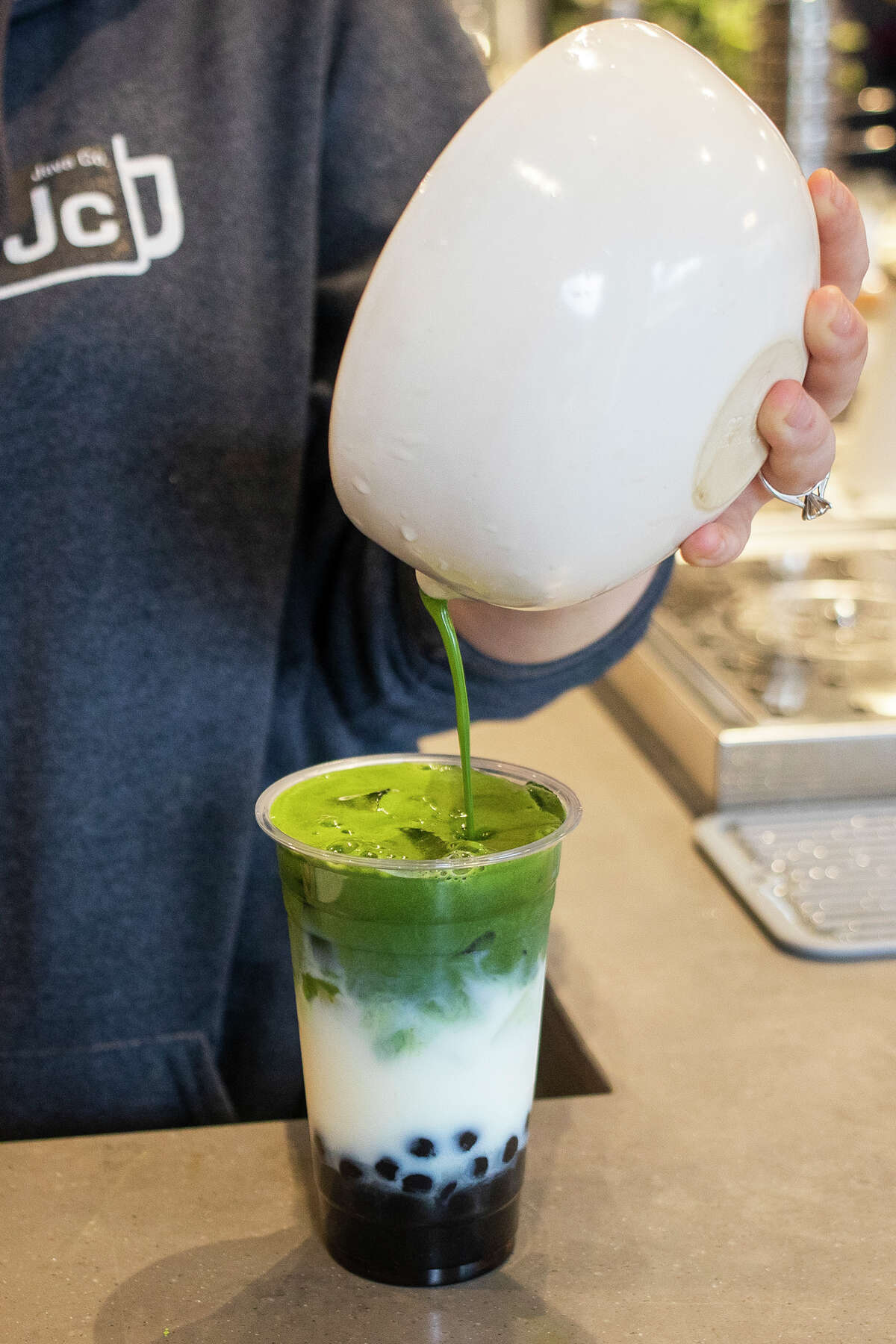 Grace LaBonte, a barista at Grove Tea Lounge, pours a matcha latte Tuesday, May 3, 2022 at the cafe in Midland.