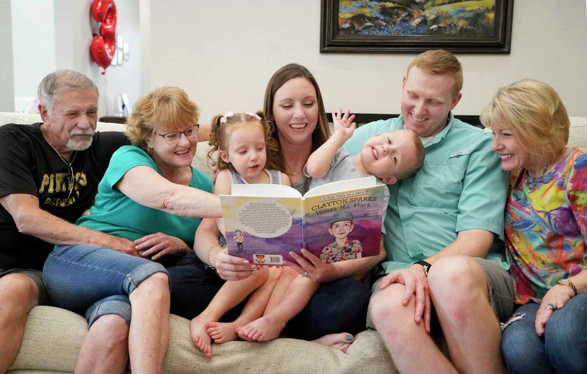 Larry Sparks, left, his wife, Beth Sparks, Abby Gray, Reid Gray, their three-year-old twins Kayle and Oliver, and Dee Everett, Abby’s mother, right, are shown Saturday, April 16, 2022, in Houston. Reid Gray, received a liver donation when Larry and Beth’s son, Clayton Sparks, died in a skiing accident in 2019. Abby Gray wrote a children’s book “Clayton Sparks Leaves His Mark.” Dee Everett was the book’s illustrator.