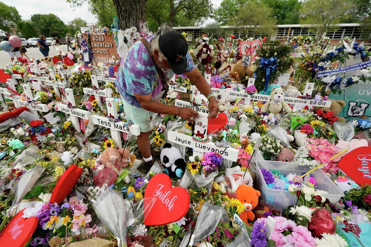 A visitor places bracelets on crosses at a memorial outside Robb Eelementary School. We call children angels, but want that to be metaphorical, not celestial. We don’t want them to be given angel’s wings before they receive their graduation rings as he and others pay their respects to the victims killed in last week's Robb Elementary School shooting, Tuesday, May 31, 2022, in Uvalde, Texas. (AP Photo/Eric Gay)