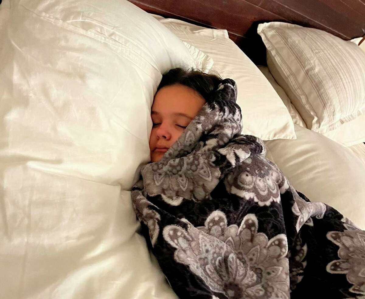 Shyne Staples, 10, falls asleep shortly after returning from a gymnastics class in San Mateo. She has experienced excess fatigue and other symptoms of long COVID since getting sick in January.