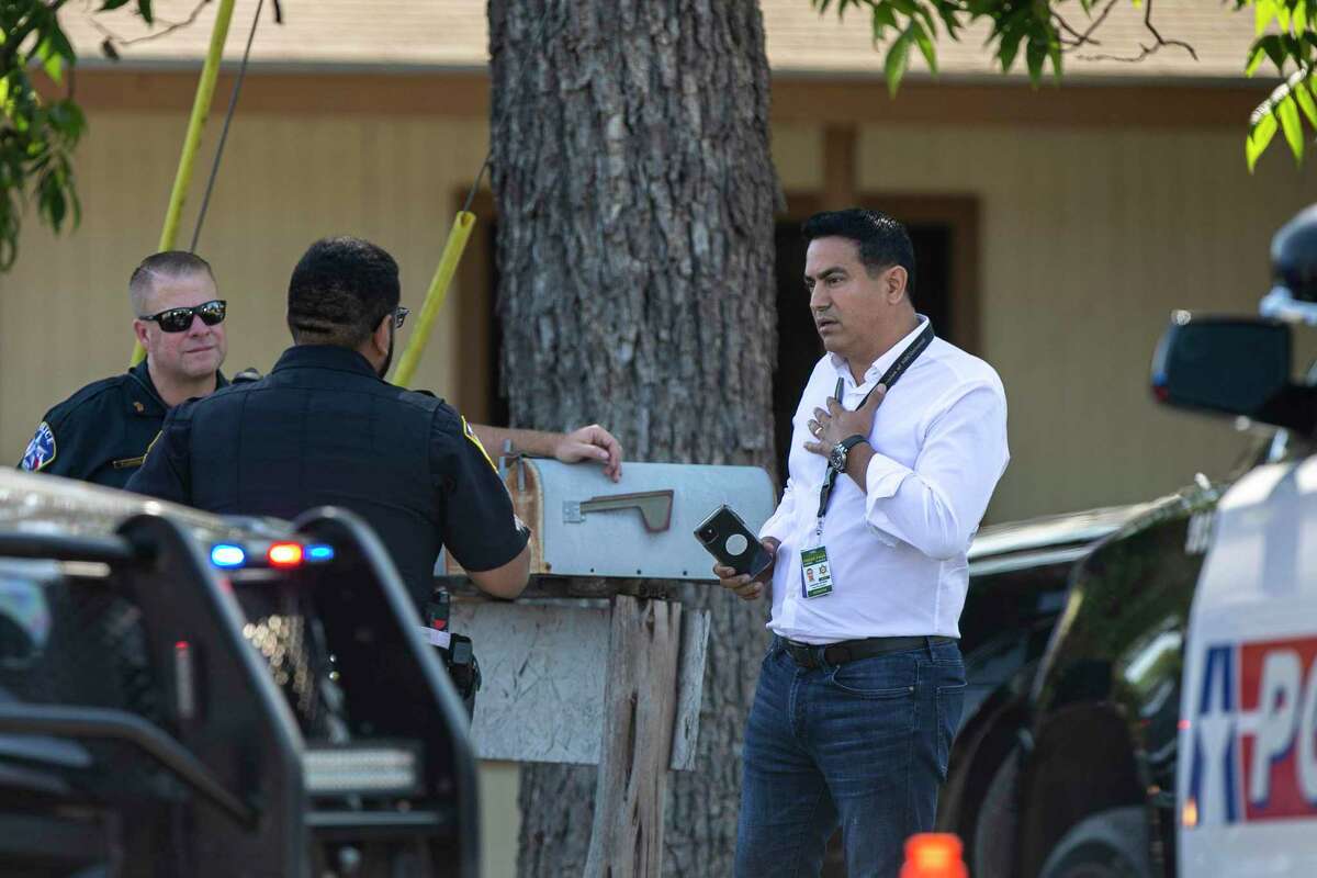 Telemundo journalist Jorge Miramontes talks with law enforcement officers after being informed that news media cannot be on public property near Sacred Heart Catholic Church in Uvalde on Friday.