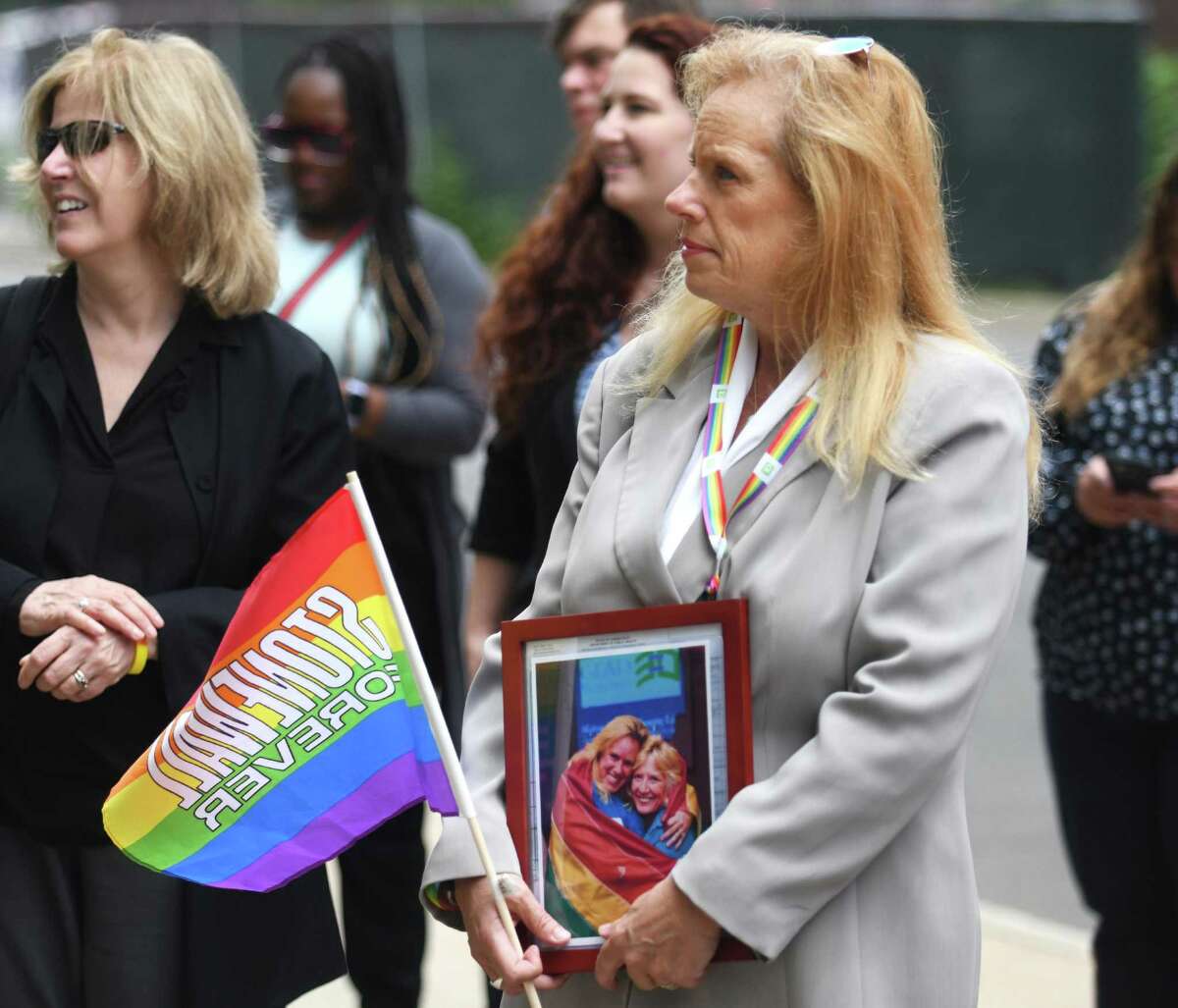 Stamford resident Maureen Boylan holds a photo of her and her wife, Barbara LeCournec, during the Pride Month flag raising outside the Government Center in Stamford, Conn. Thursday, June 2, 2022. Stamford Mayor Caroline Simmons joined Stamford Pride outside the Government Center to raise a rainbow flag kicking off LGBTQ+ Pride Month.