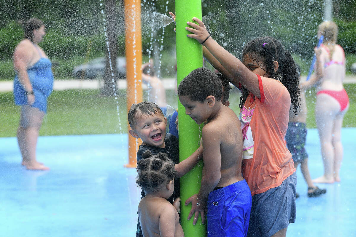 From left. Gabriel Sanchez and Christian, Kameron and Khy'Leigh Fernau gather round one of the spray stations while enjoying the splash pad at Rogers Park Friday. Photo made Friday, June 3, 2022. Kim Brent/The Enterprise