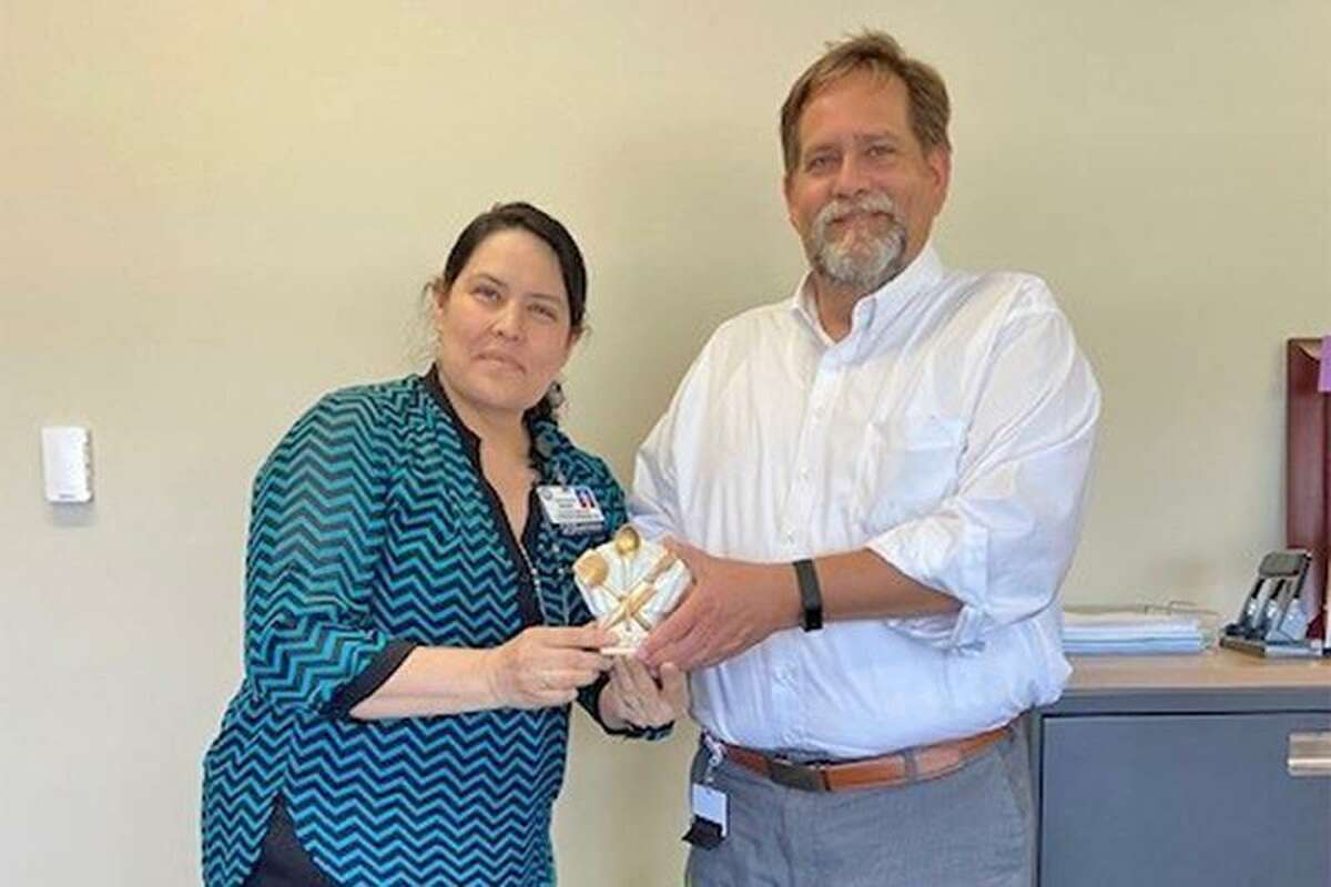 Diana Brown, quality assurance and compliance coordinator for schools, left, receives her No Kid Hungry Texas Hunger Hero Hall of Fame trophy from Darin Crawford, assistant superintendent of support services. Brown was one of five individuals included in the inaugural class inducted into the Hunger Hero Hall of Fame.