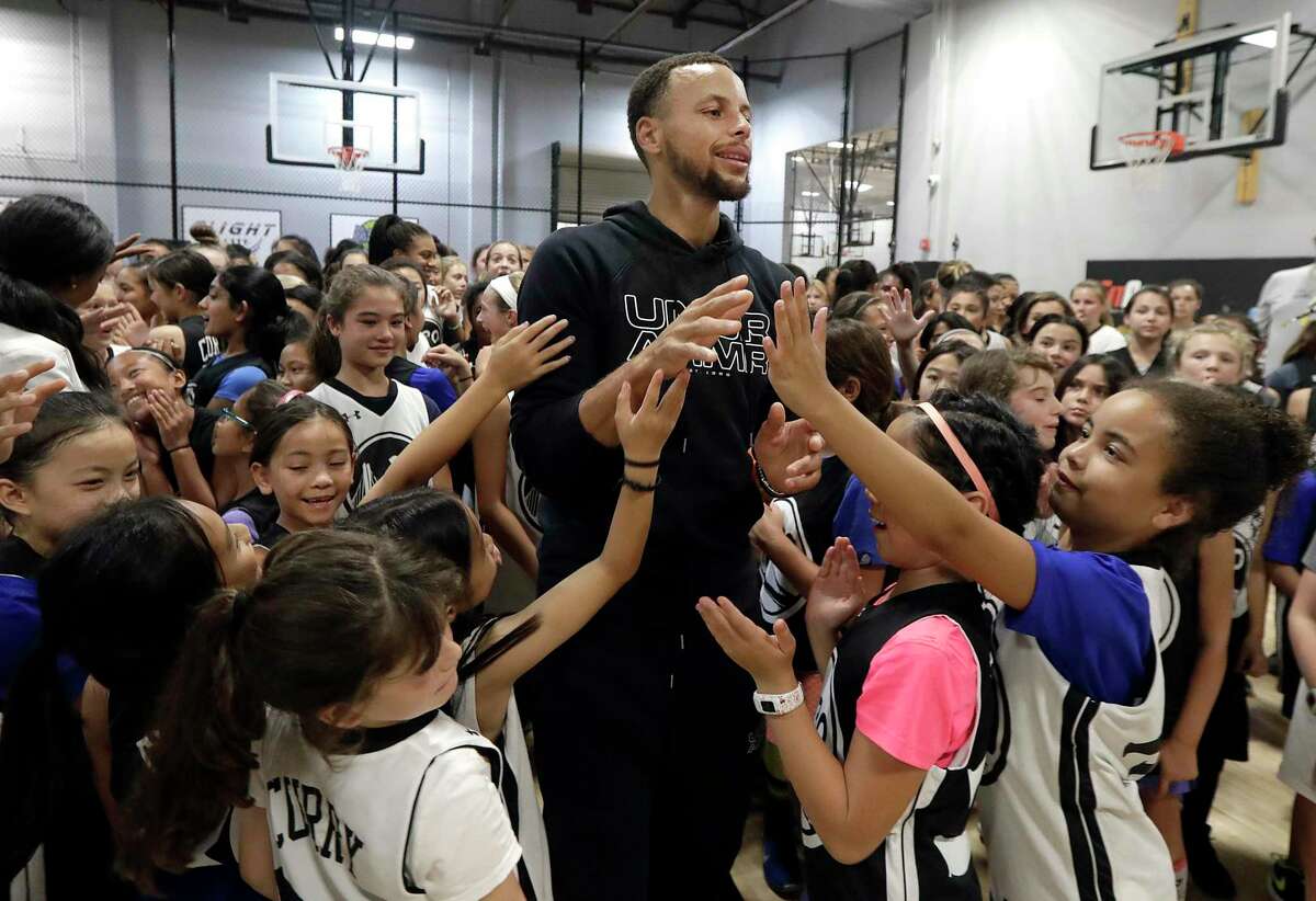 Golden State Warriors’ Stephen Curry, center, greets basketball camp participants at Ultimate Fieldhouse in Walnut Creek.