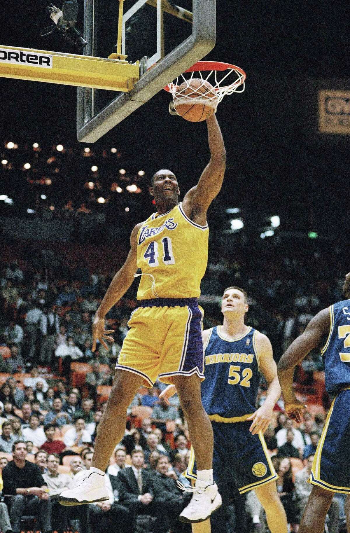 Los Angeles Lakers center Elden Campbell (41) slams for two of his team-high 26 points over Golden State Warriors center Todd Fuller in a 1997 Lakers victory.