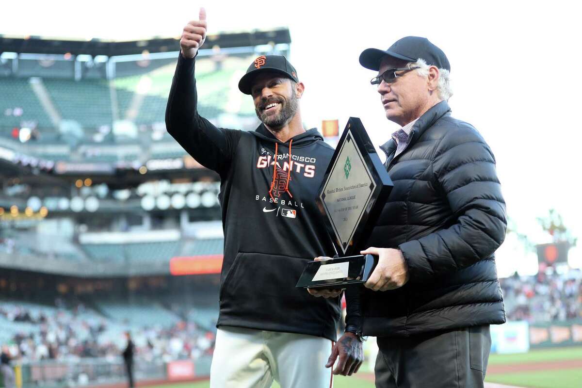 San Francisco Giants’ manager Gabe Kapler accepts 2021 Manager of the Year award from Baseball Writers' Association of America’s John Shea before Giants play San Diego Padres during MLB game at Oracle Park in San Francisco, Calif, on Monday, April 11, 2022.