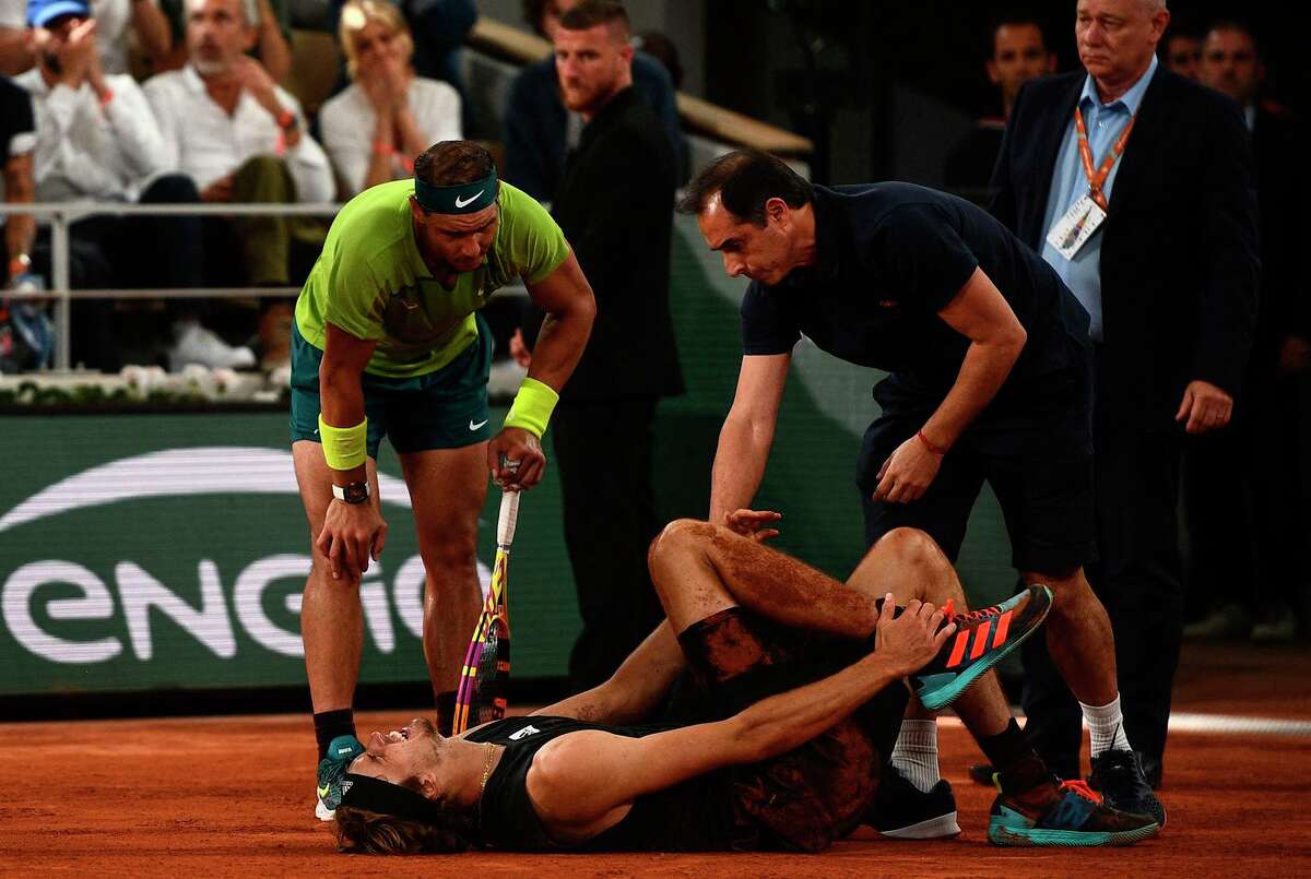 Rafael Nadal checks on his French Open semifinals opponent, Alexander Zverev, who suffered an apparent ankle injury during the match. Zverev had to retire, sending Nadal to the final.