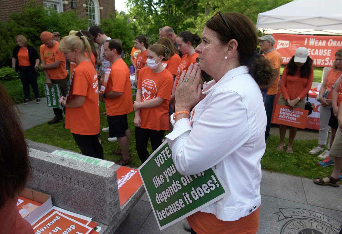 Beth Hegarty, of Newtown, prays at the start of a rally for action that was held Friday evening in front of Edmond Town Hall in Newtown on National Gun Violence Awareness Da.y.
