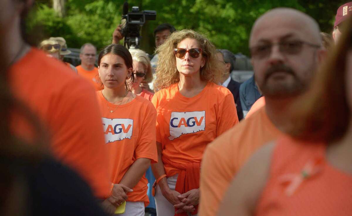 Jennifer Masone, of Weston, listens to a speech at a rally for action held Friday evening in front of Edmond Town Hall on National Gun Violence Awareness Day. June 3, 2022, Newtown, Conn.
