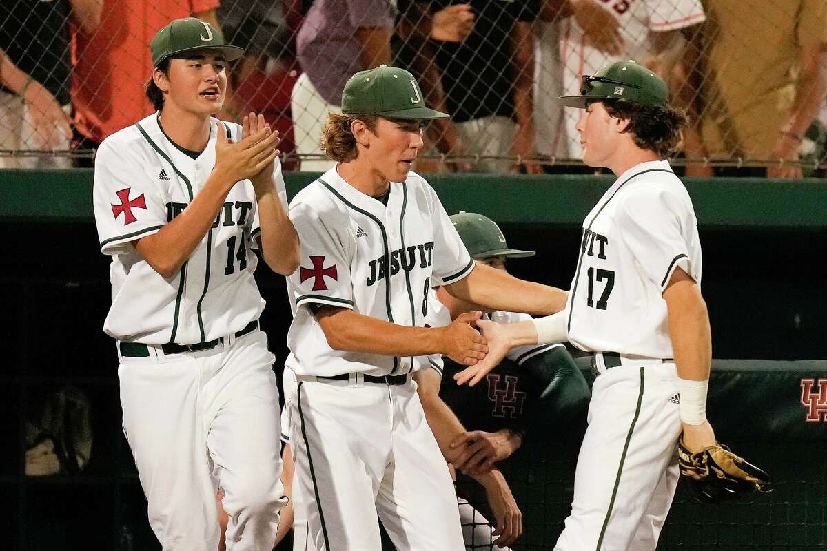 Strake Jesuit third baseman Shane Pellegrino (17) celebrates tagging out Ridge Point's Jake Stratton's steal attempt of third base with Jack Magnus, center, and Luke Eumont during the sixth inning of Game 2 of the Region III-6A Championship high school baseball playoff series, Friday, June 3, 2022, in Houston.