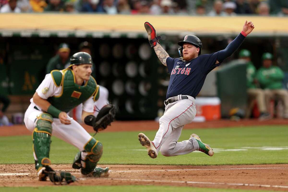 OAKLAND, CALIFORNIA - JUNE 03: Alex Verdugo #99 of the Boston Red Sox slides past Sean Murphy #12 of the Oakland Athletics to score on a hit by Franchy Cordero #16 in the fourth inning at RingCentral Coliseum on June 03, 2022 in Oakland, California. (Photo by Ezra Shaw/Getty Images)