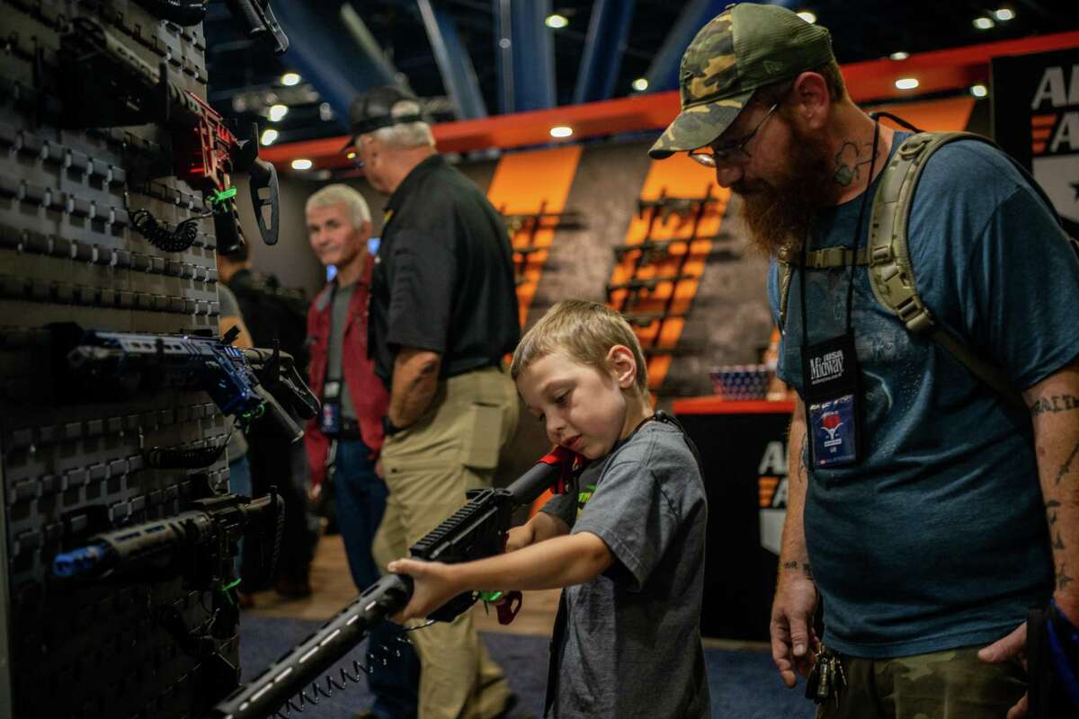 HOUSTON, TEXAS - MAY 28: Chris Shelton, 36, oversees his son Luke Shelton, 7, as he steadies an AR-15 rifle at the George R. Brown Convention Center during the National Rifle Association (NRA) annual convention on May 28, 2022 in Houston, Texas. "I believe the first and foremost thing children should learn, or anyone holding a firearm, is firearm safety. The first rule of firearm safety is that your finger should not go on the trigger until you are ready to shoot and I've taught my son that over the last 3 years. I've seen him be more disciplined in that than most of the people here. Now that he's 7, I have no problem with handing him a fully loaded firearm because I am 100% confident that he will be safe," said Luke Shelton's father Chris when asked about allowing his son to engage with firearms. The annual National Rifle Association convention comes days after the mass shooting in Uvalde, Texas which left 19 students and 2 adults dead, with the gunman fatally shot by law enforcement officers. (Photo by Brandon Bell/Getty Images)