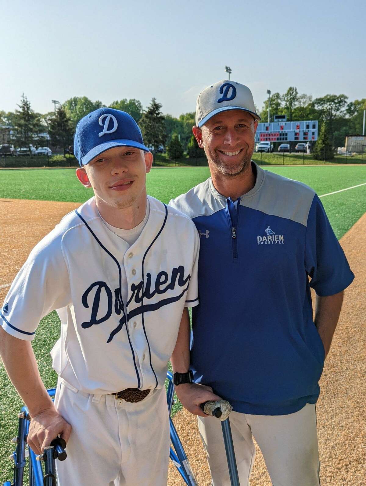 Darien senior Alex Baird, left, and baseball coach Mike Scott. Scott put senior team manager Baird, who has cerebral palsy, into the last game of the season for a stint on the mound.
