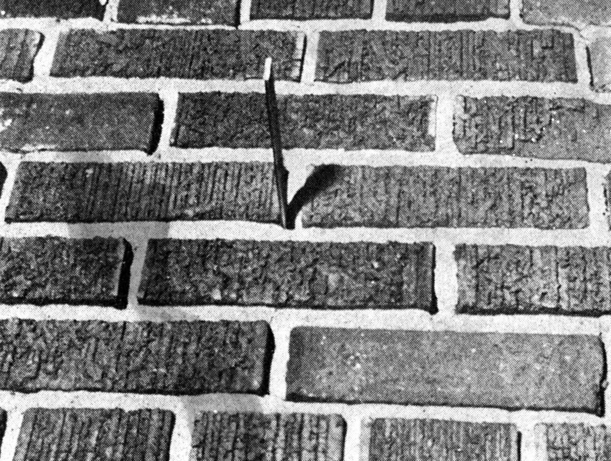 A ruler was easily inserted completely through the mortarless joint in a portion of deteriorated brickwork at the second-story level of Washington School. Facing of many bricks shown has broken away, both conditions being common to the school's exterior. The photo was published in the News Advocate on June 6, 1962.
