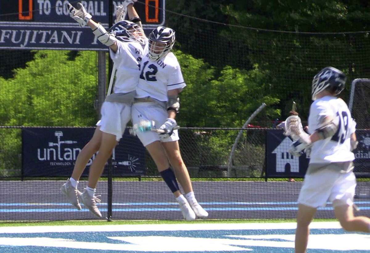 Wilton’s Charlie Johnson, left, celebrates his overtime goal with Sean Wiseman as Grant Masterson runs in to join them. Wilton defeated Hand 10-9 in overtime in the Class M quarterfinals Saturday.