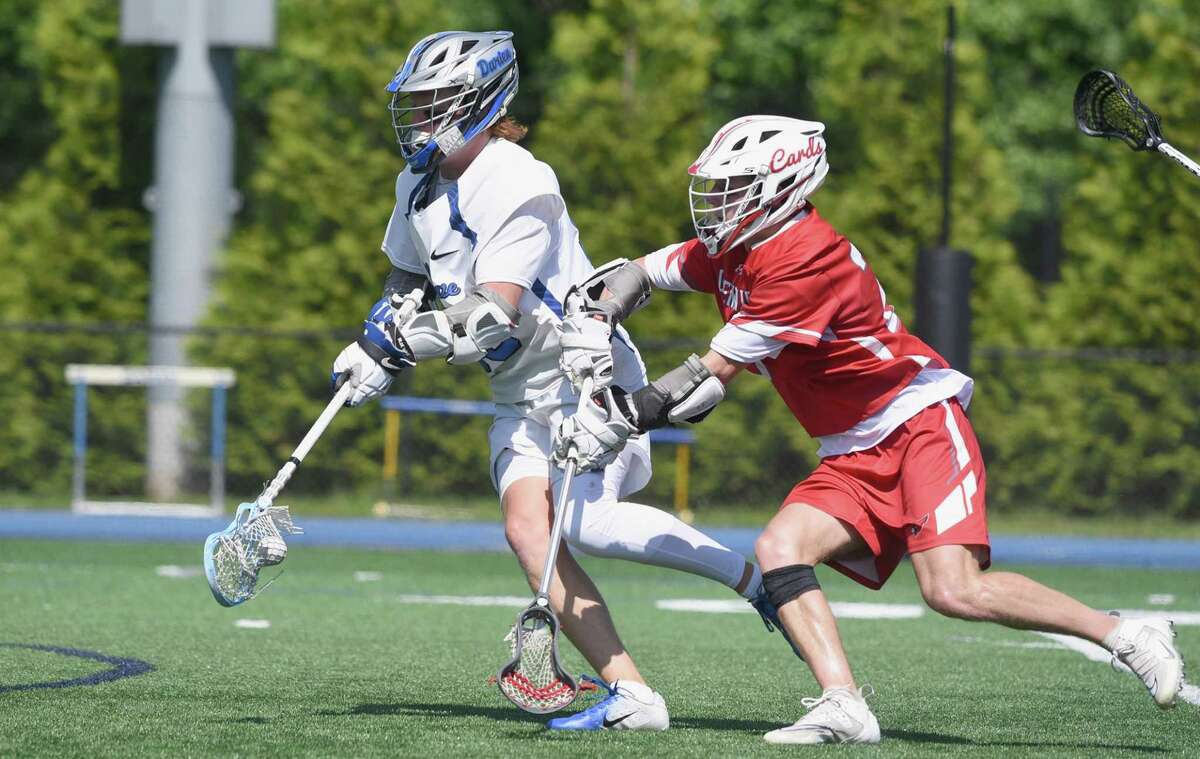 Darien’s Brady Pokorny (99) gets out in front of Greenwich’s Wesley Zolin (25) during the Class L boys lacrosse quarterfinals in Darien on Saturday.