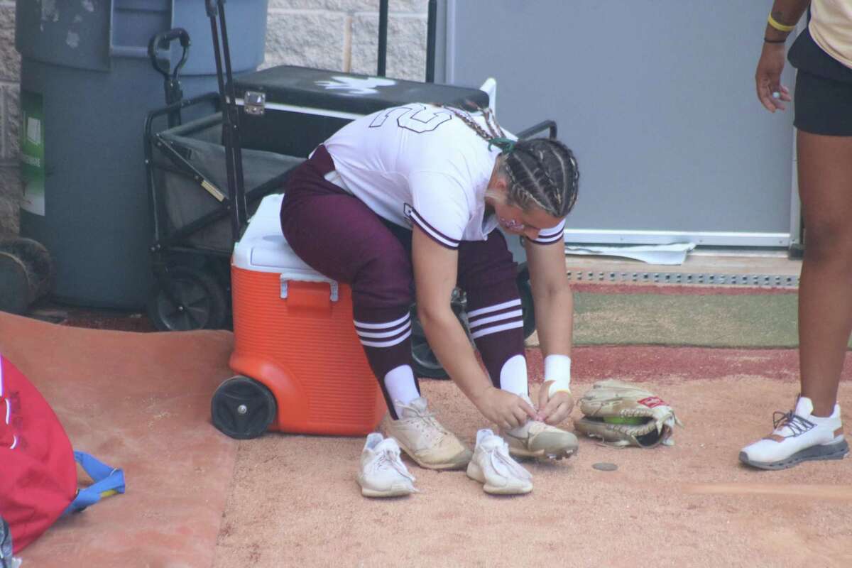 Deer Park starting pitcher Reanna Nieman puts on her cleats in the Lady Deer bullpen as she readies for her starting assignment in the circle Friday night in Austin.