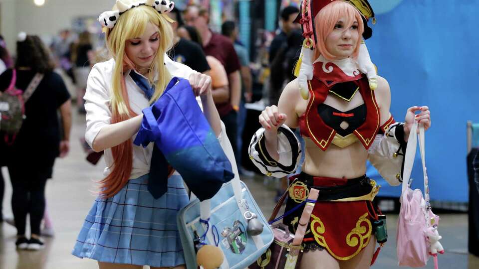 Cosplay attendees dressed as Genshin Impact anime characters walk the booths during the KimoKawaii Anime Con held at the Lone Star Convention Center on Saturday in Conroe.