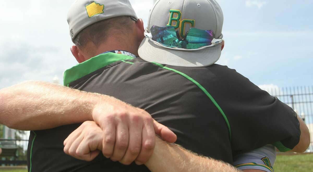 Brown County coach Jared Hoots embraces Colby Wort after the final huddle following the Hornets' loss to Louisville in the IHSA Class 1A state championship game at Dozer Park in Peoria on Saturday.