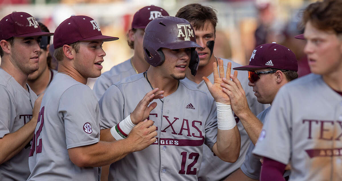 Texas A&M's Troy Claunch (12) celebrates with teammates after scoring against Louisiana during an NCAA college baseball tournament regional game Saturday, June 4, 2022, in College Station, Texas. (Michael Miller/College Station Eagle via AP)