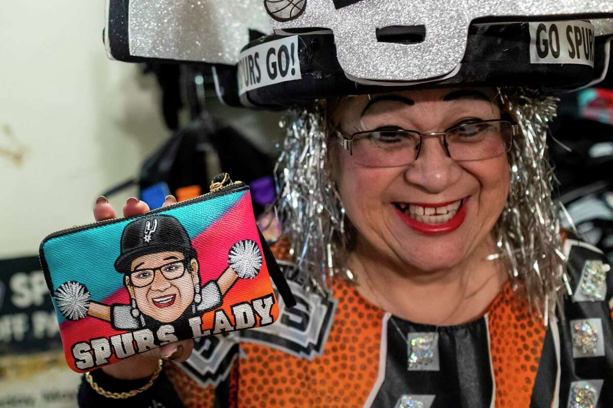 Sovia Lauriano, 69, shows off a Spurs Lady wallet at her home in San Antonio on June 2. For the past 25 years, Lauriano has proudly upheld the title of “Spurs Lady” due to her undying loyalty to the San Antonio Spurs and her eclectic handmade outfits in honor of the silver and black.