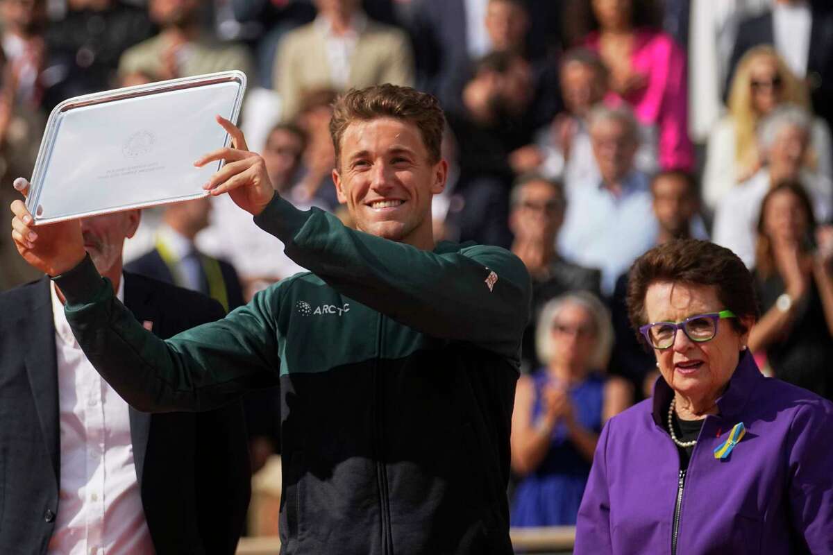 Norway's Casper Ruud holds the trophy for second place as U.S. tennis legend Billie Jean King watches, right, after Ruud lost final match against Spain's Rafael Nadal at the French Open tennis tournament in Roland Garros stadium in Paris, France, Sunday, June 5, 2022. (AP Photo/Michel Euler)