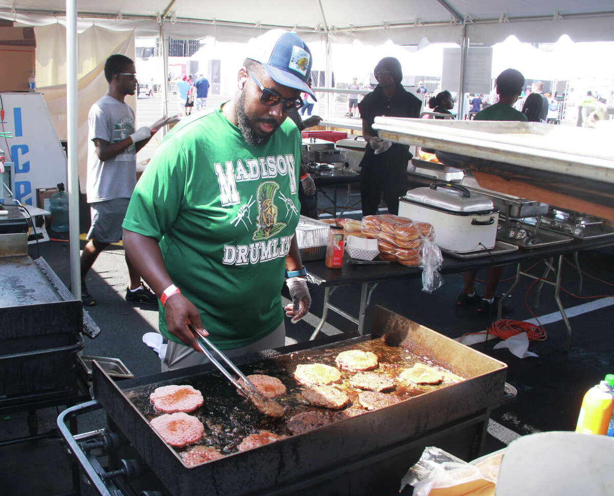 Bernard Long Jr. cooks hamburgers in a food stand Sunday morning during the Enjoy Illinois 300 NASCAR Cup Series race at World Wide Technology Raceway in Madison. The Madison High School Band was working the stand as a fund-raiser for an upcoming trip to London, England.