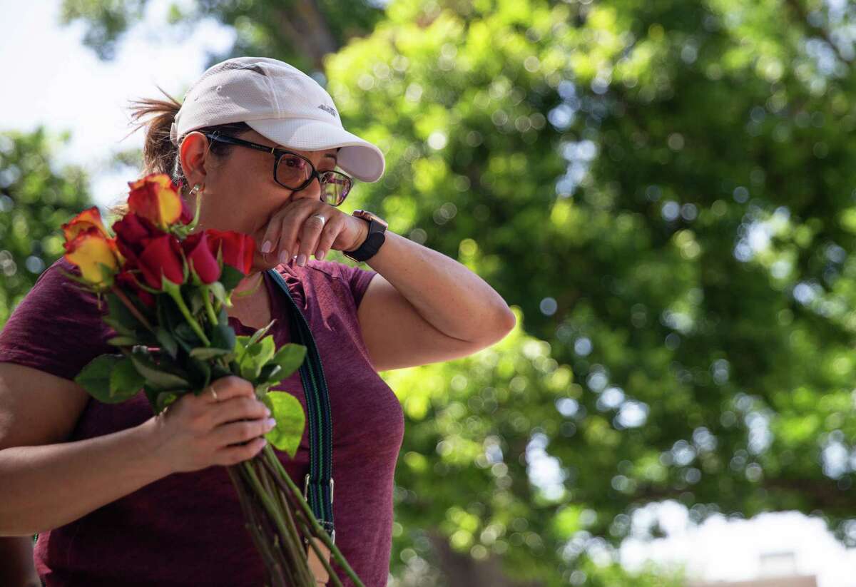 Debra Cruz, of San Antonio, wipes tears off her face as she spends time , and lays roses at each cross representing the 21 victims of the Uvalde massacre at the townsquare memorial Sunday, June 5, 2022, in Uvalde. It was Cruz’s second Sunday in a row to visit the memorial because she wanted to show her support and pay respect.