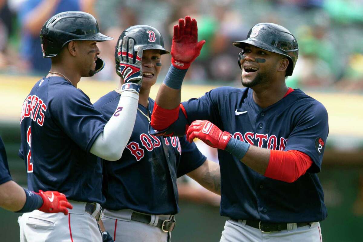 Boston Red Sox's Franchy Cordero, right is greeted by teammates Xander Bogaerts (2) and Rafael Devers after hitting a three-run home run off Oakland Athletics starting pitcher Frankie Montas during the inning of a baseball game, Sunday, June 5, 2022, in Oakland, Calif. (AP Photo/D. Ross Cameron)