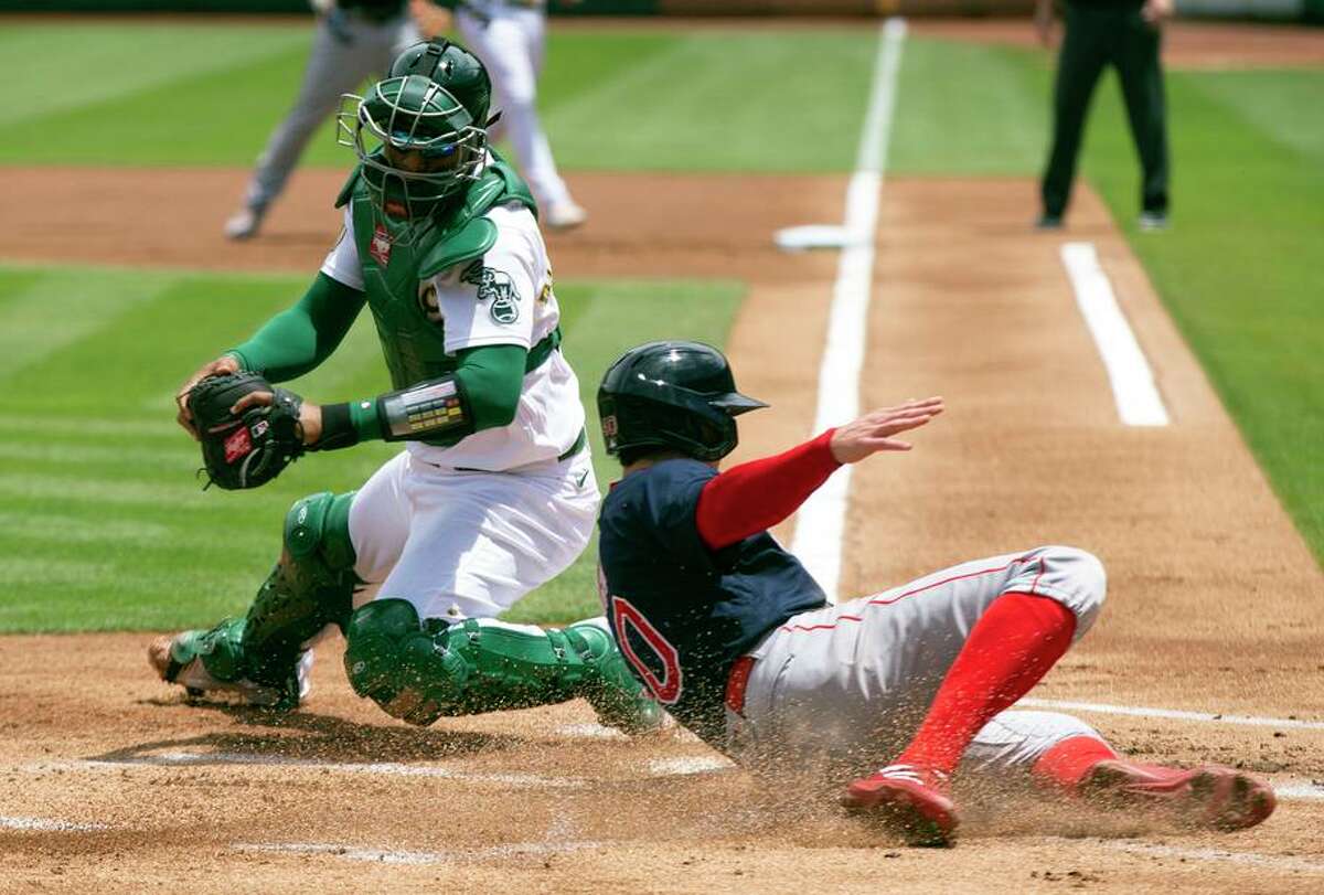 Red Sox designated hitter Jarren Duran slides safely home in the first inning of Boston’s 5-2 win Sunday.