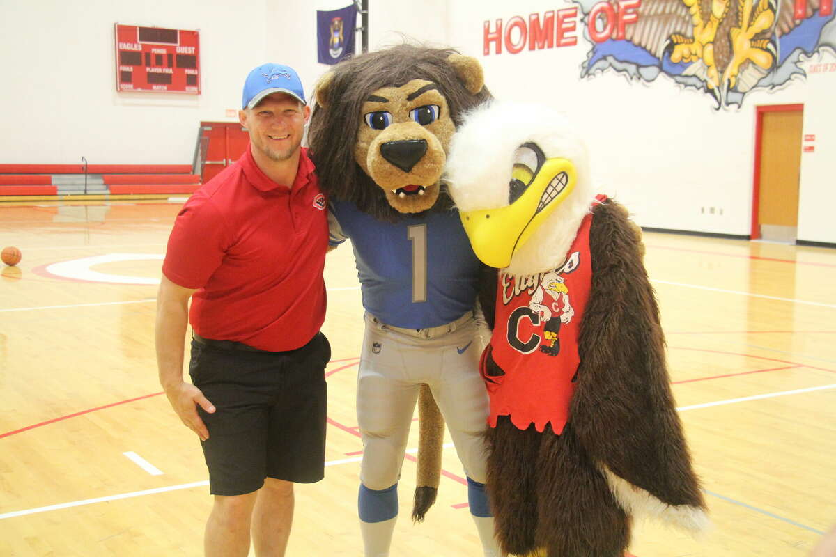 Roary, the Detroit Lions mascot, and the Caseville Eagles mascot with Caseville footbal coach Sam Rogers.