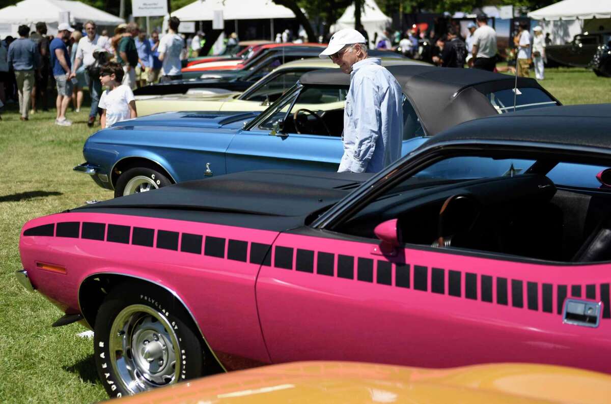 Mike Ipp, of Livingston, N.J., looks at Joy Curran’s pink 1970 Plymouth AAR Cuda at the Greenwich Concours d’Elegance car show at Roger Sherman Baldwin Park in Greenwich, Conn. Sunday, June 5, 2022. The multiday event featured hundreds of cars in a variety of categories on display, speakers, awards, kids events, food, and more.