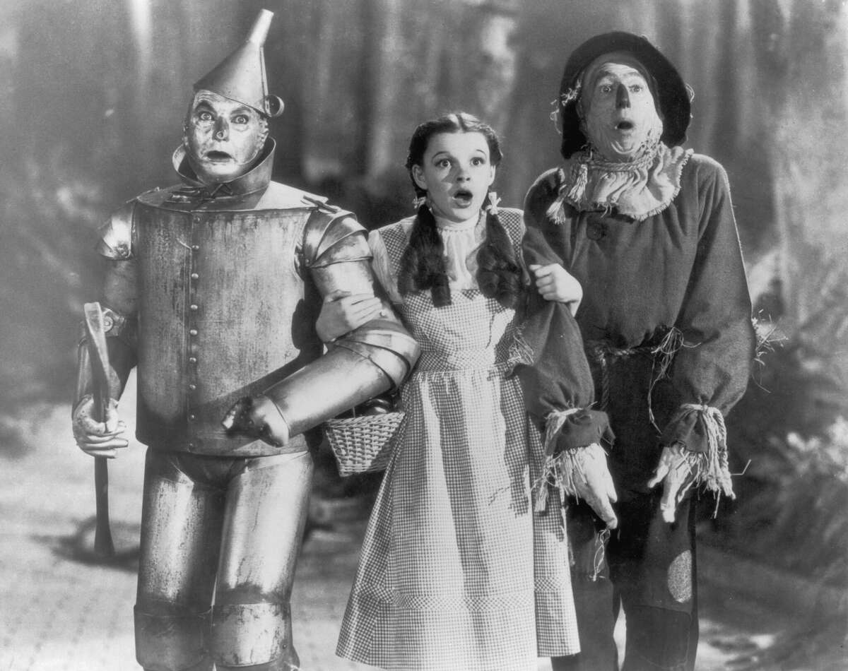 The Tin Man (Jack Haley), Dorothy (Judy Garland) and the Scarecrow (Ray Bolger) set off on their quest for fulfillment in the children's classic 'The Wizard of Oz', directed by Victor Fleming for MGM, 1939. (Photo by FPG/Hulton Archive/Getty Images)
