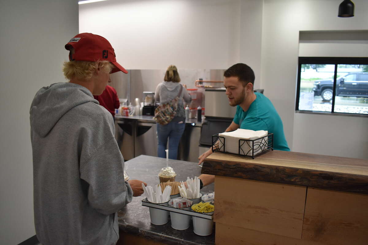 Ebels General Store held a soft opening for the new coffee shop and clothing store, an expansion of the existing Ebels General Store in Reed City. Above, Chase DeMott slides a customer their drink.
