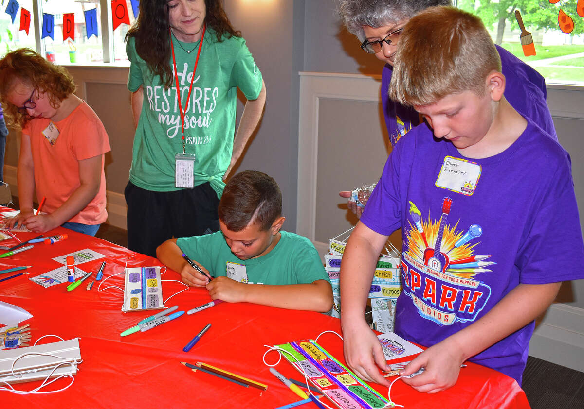 Abby Potter (from left), Wesley Teek and Elliott Brammerier create inspirational message signs during Vacation Bible School at Lincoln Avenue Baptist Church. 