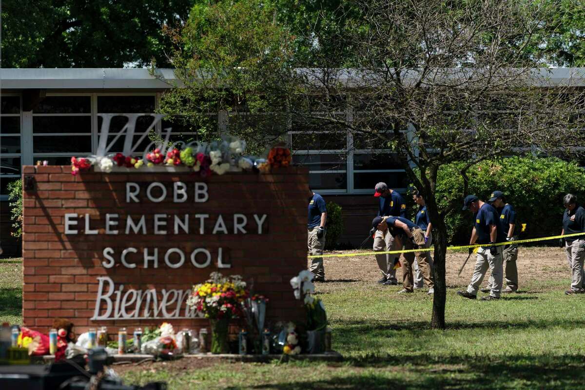 FILE - Investigators search for evidences outside Robb Elementary School in Uvalde, Texas, May 25, 2022. The children who survived the attack, which killed 19 schoolchildren and two teachers, described a festive, end-of-the-school-year day that quickly turned to terror.