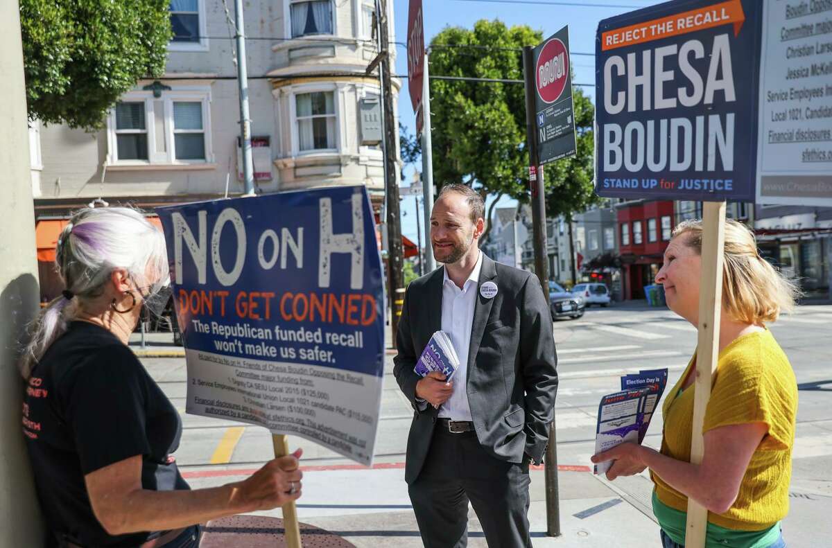 District Attorney Chesa Boudin talks to volunteers Gail E. (left) and Ymilul B. as he campaigns in Cole Valley on Monday, the day before the recall vote.