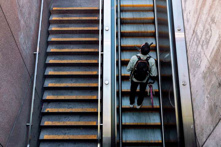 A commuter rides the escalator exiting the Embarcadero Bart Station.